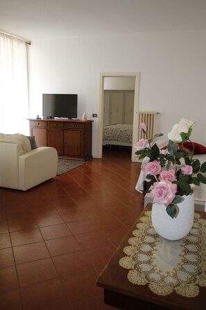 Relax in this stylish living room with a flat-screen TV, comfortable sofa, and decorative vase.