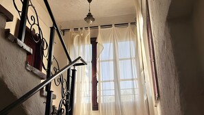 Una scala con ringhiera in metallo e una ventola a soffitto.