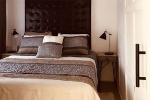 Restful retreat with a large bed, tufted headboard, and two bedside tables.
