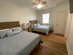 Cozy retreat with a large bed, bedside tables, and a ceiling fan.