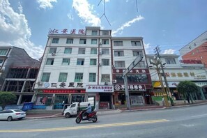 A multi-story building with commercial establishments on the ground floor, including a pharmacy and a restaurant.