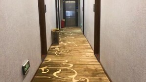 A hallway with a patterned carpet and a door at the end. - Afuer Chain Smart Hotel (Weixin Lianyi Branch) (Weixin)