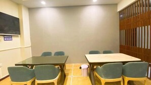 A conference room with two tables, six chairs, a blackboard, and a trash bin. - Afuer Chain Smart Hotel (Weixin Lianyi Branch) (Weixin)