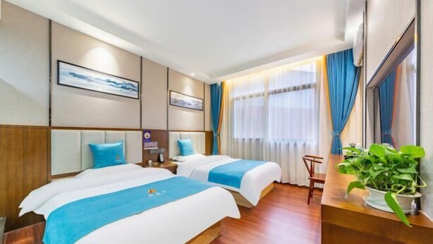 A hotel room with two beds, a wooden headboard, a bedside table, a plant, and a window with curtains. - Afuer Chain Smart Hotel (Weixin Lianyi Branch) (Weixin)