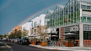 A modern building with a glass facade and the name "Uchi" on the front. - Jungle House: 2 Bed Condo w/parking & Patio (Denver)