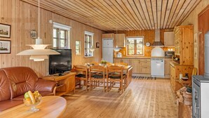 A cozy cabin interior with a dining area, kitchen, and living room.