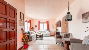 A spacious living room with a fireplace, a coffee table, and a sofa set.