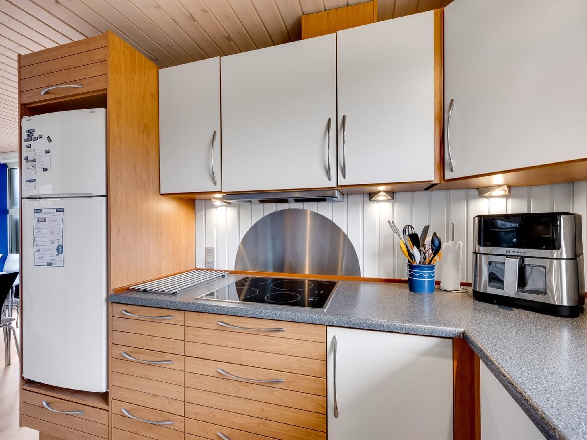 A compact kitchen with a built-in stove, a microwave, and a refrigerator.