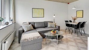 A modern living room with a grey sofa, a glass coffee table, and a dining area with black chairs. - "Skarthi" - 20km from the sea by Interhome (Skærbæk)