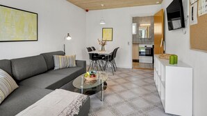 A modern living room with a grey sofa, a glass coffee table, and a dining area with a white table and black chairs. - "Skarthi" - 20km from the sea by Interhome (Skærbæk)