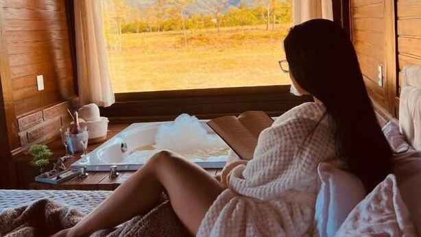 Interno accogliente di una baita con un'ampia finestra che si affaccia su un paesaggio montano.