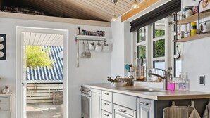 A modern kitchen with a built-in oven, stainless steel appliances, and a large window. - "Tameka" - 10m to the fjord by Interhome (Munkebo)