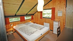 A wooden cabin bedroom with two beds, a desk, and a window with curtains. - "Spasena" - 400m from the sea by Interhome (Gedser)
