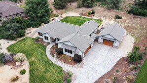 A two-story house with a garage, a covered driveway, and a well-maintained lawn. - Cozy Retreat Family Home (Klamath Falls, OR)