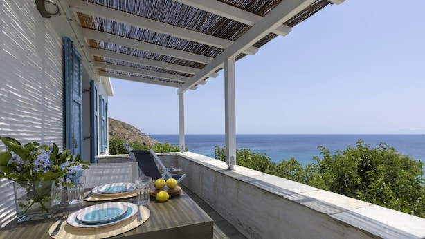 Una terraza con una mesa lista para dos, con vista al mar.