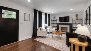 Uma sala de estar moderna com lareira, televisão e área de refeições.