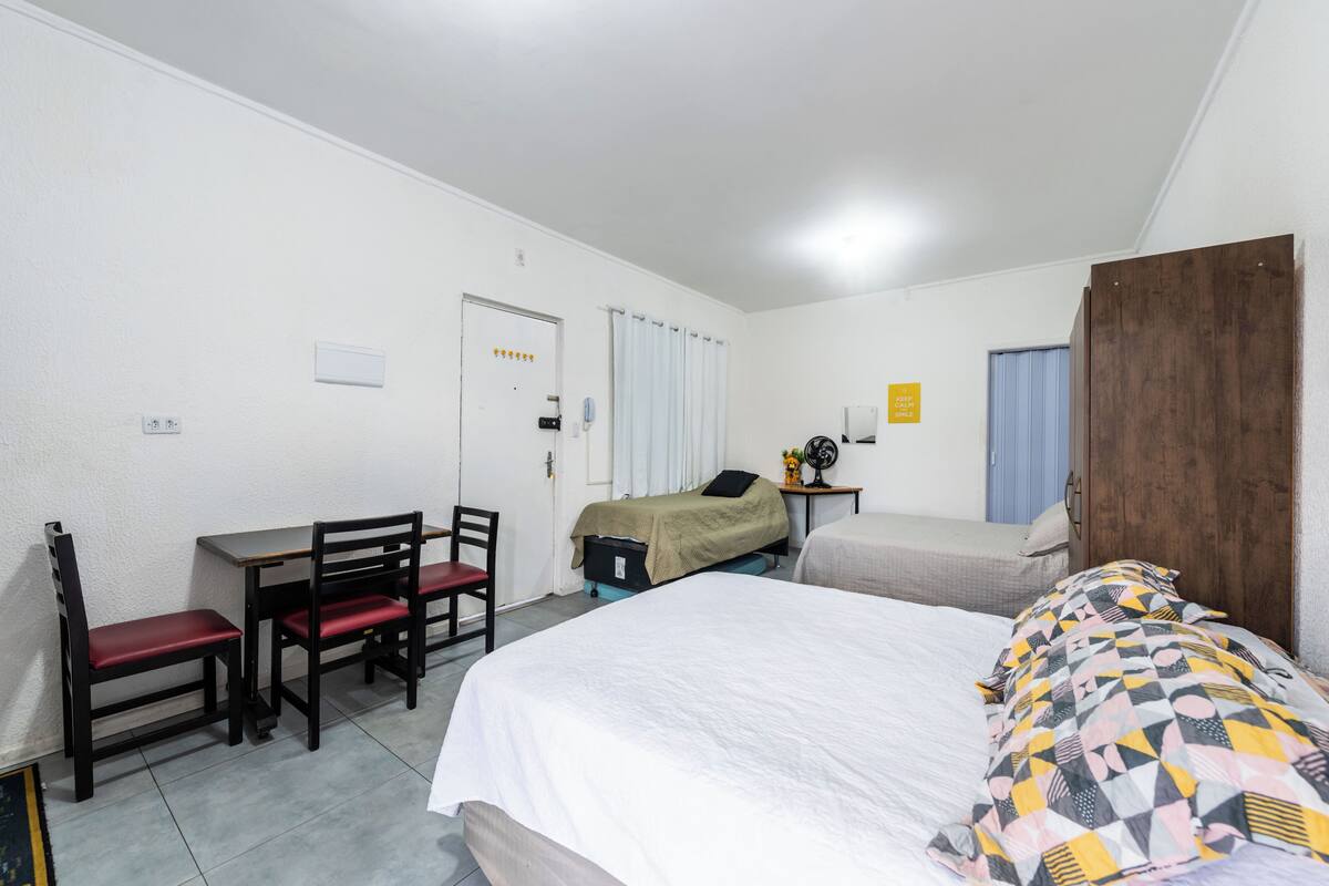 Una camera da letto con un letto, una scrivania con sedie, un tavolino e un armadio.