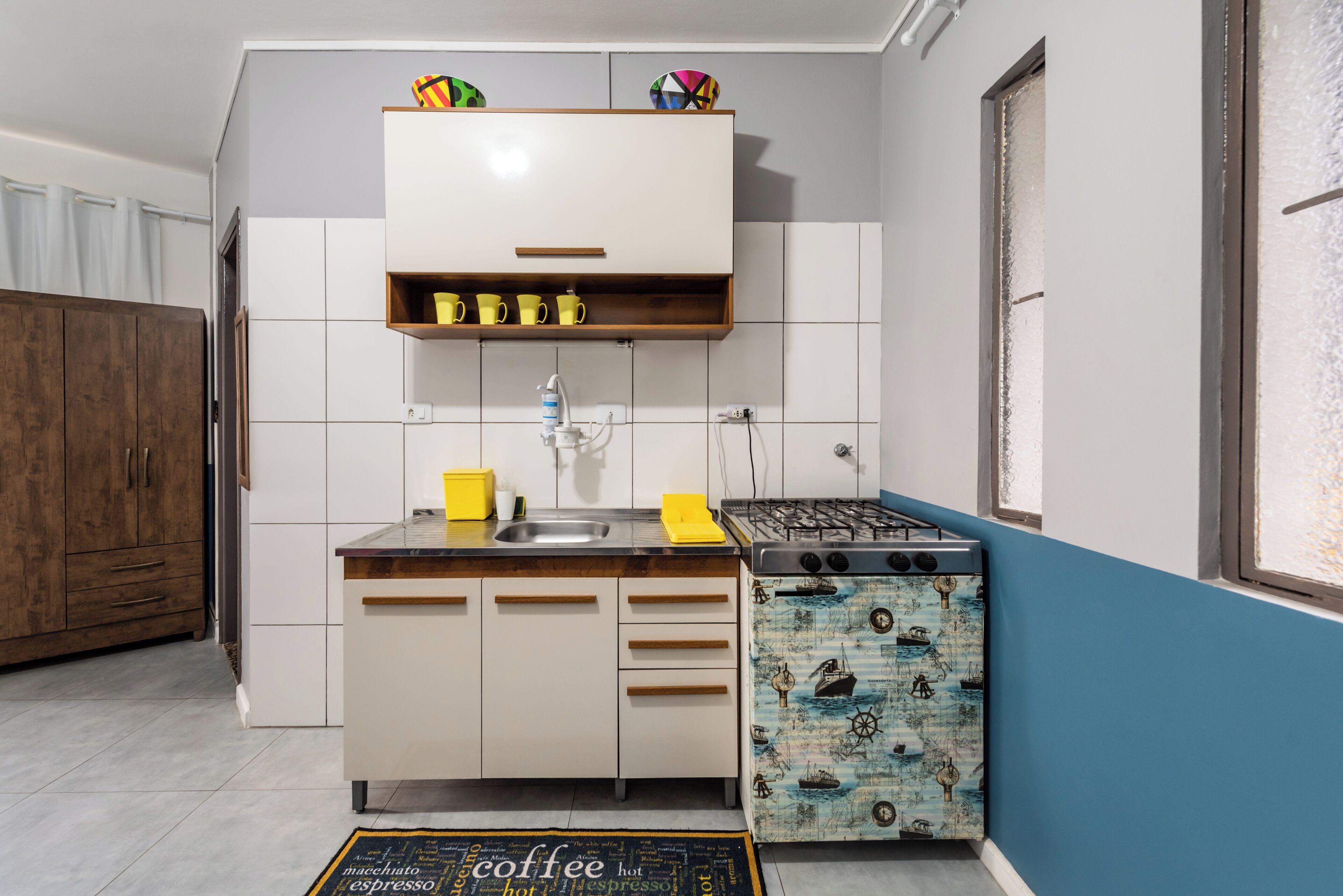 Una cucina con fornello, lavello e pensili.