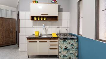 Una cucina con fornello, lavello e pensili.