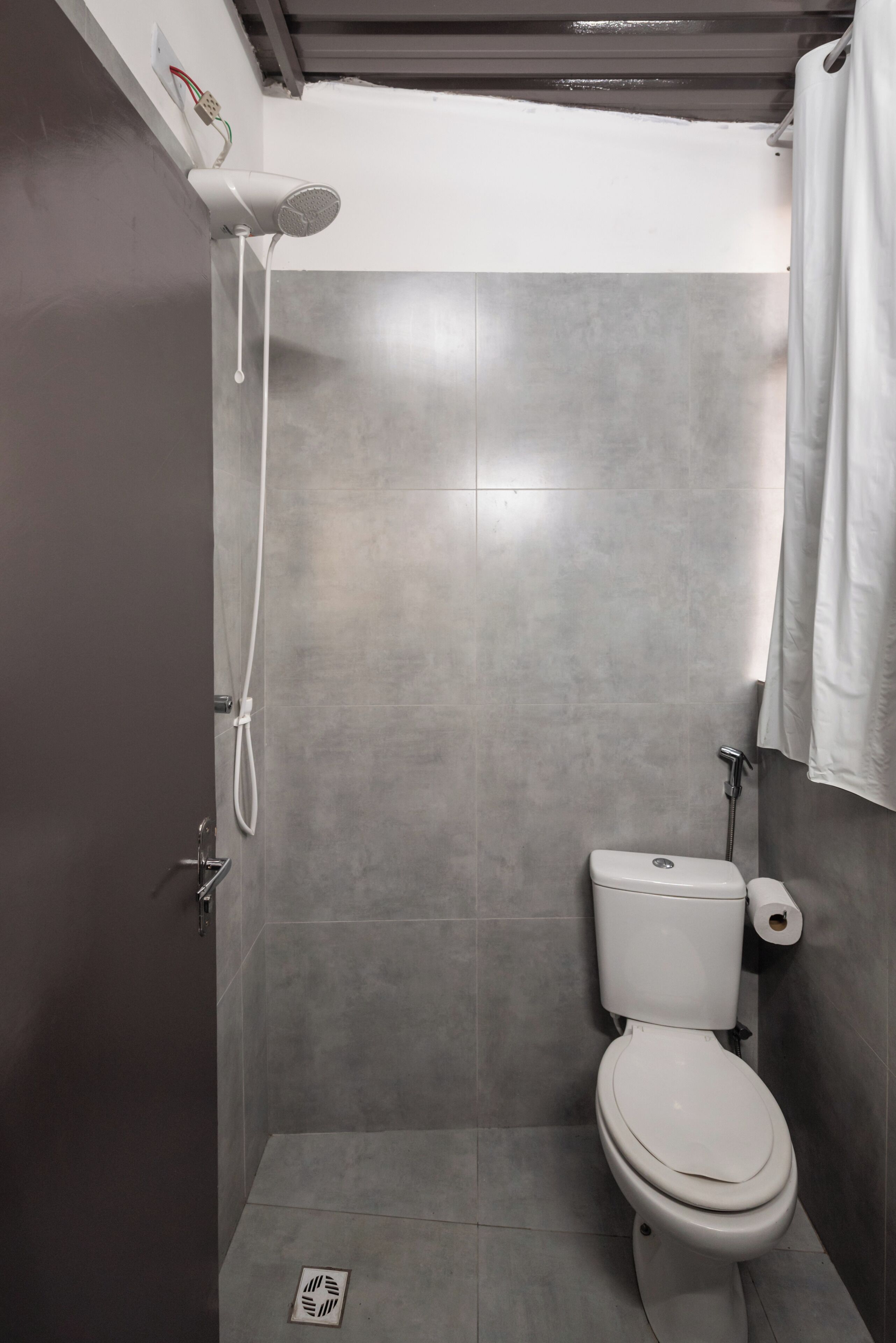 Un baño con ducha, inodoro y una toalla colgada en la pared.