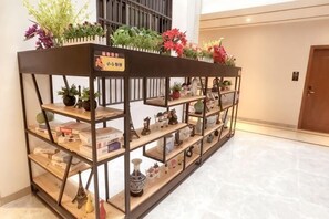 A display of books and decorative items on shelves in a hotel lobby. - Haolong Hotel (Qionghai Yinhai Road Grain Street Branch) (Qionghai)