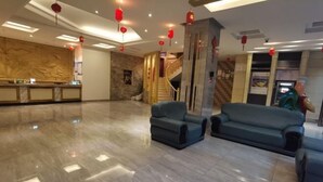 A spacious lobby with a marble floor, a reception desk, and a staircase leading to upper floors. - Haolong Hotel (Qionghai Yinhai Road Grain Street Branch) (Qionghai)
