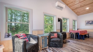 A cozy cabin with large windows, a fireplace, and a dining area. - Dog Friendly, Cozy, Private, Convenient | Long Lake Lookout (Cohasset)
