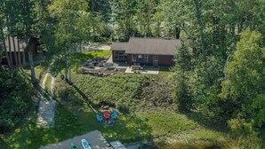 A house with a backyard, a small pond, and kayaks.