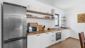 A modern kitchen with a stainless steel refrigerator, a microwave, a sink, and wooden countertops. - Vesna Branka in Pi an (Pican)