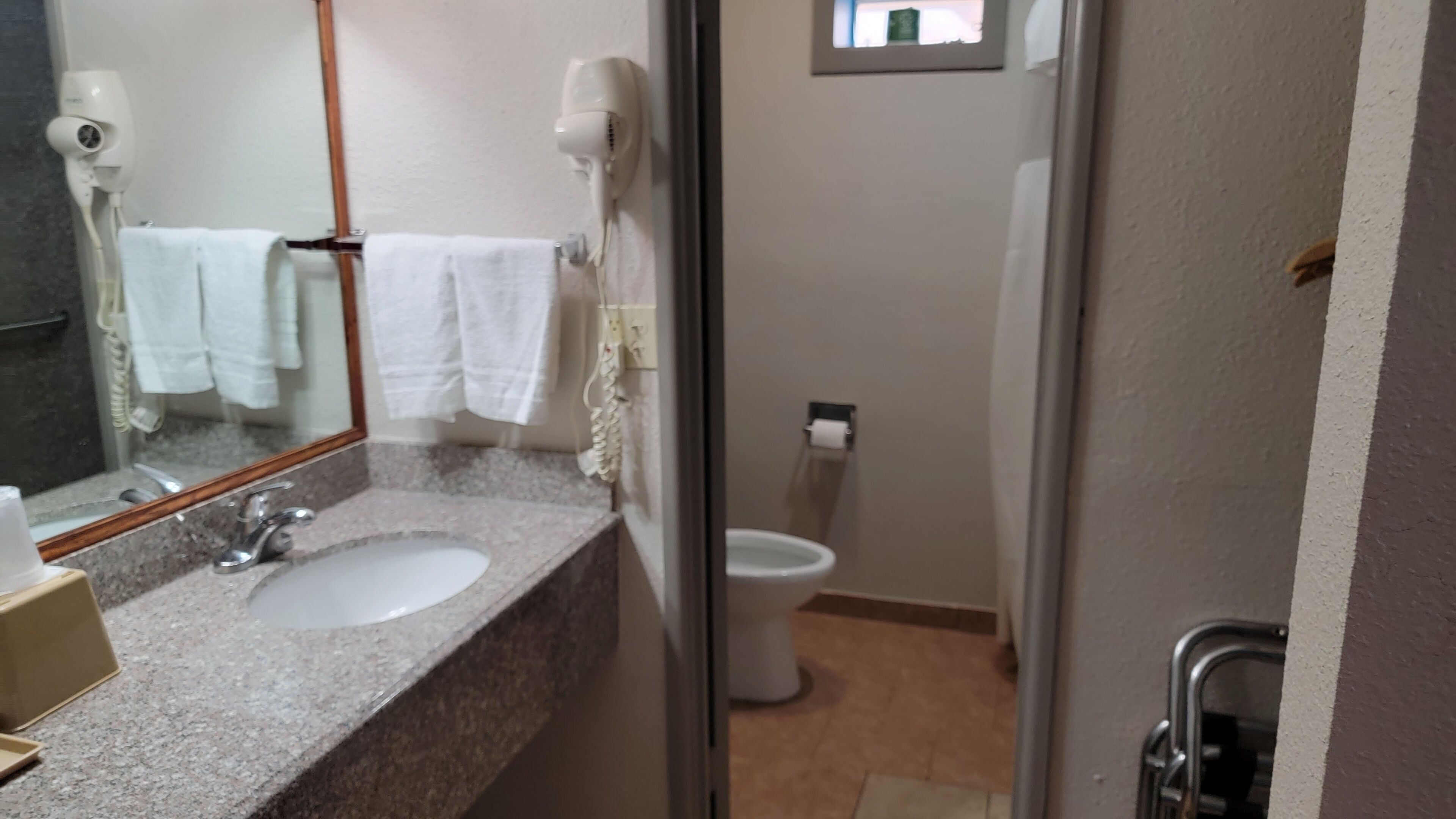 Une salle de bain avec un lavabo, un miroir et des toilettes.