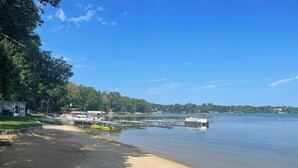 A lakeside area with a dock, boats, and a small building. - Guest House at Geneva Beach Resort - Views of Lake Geneva (Alexandria)