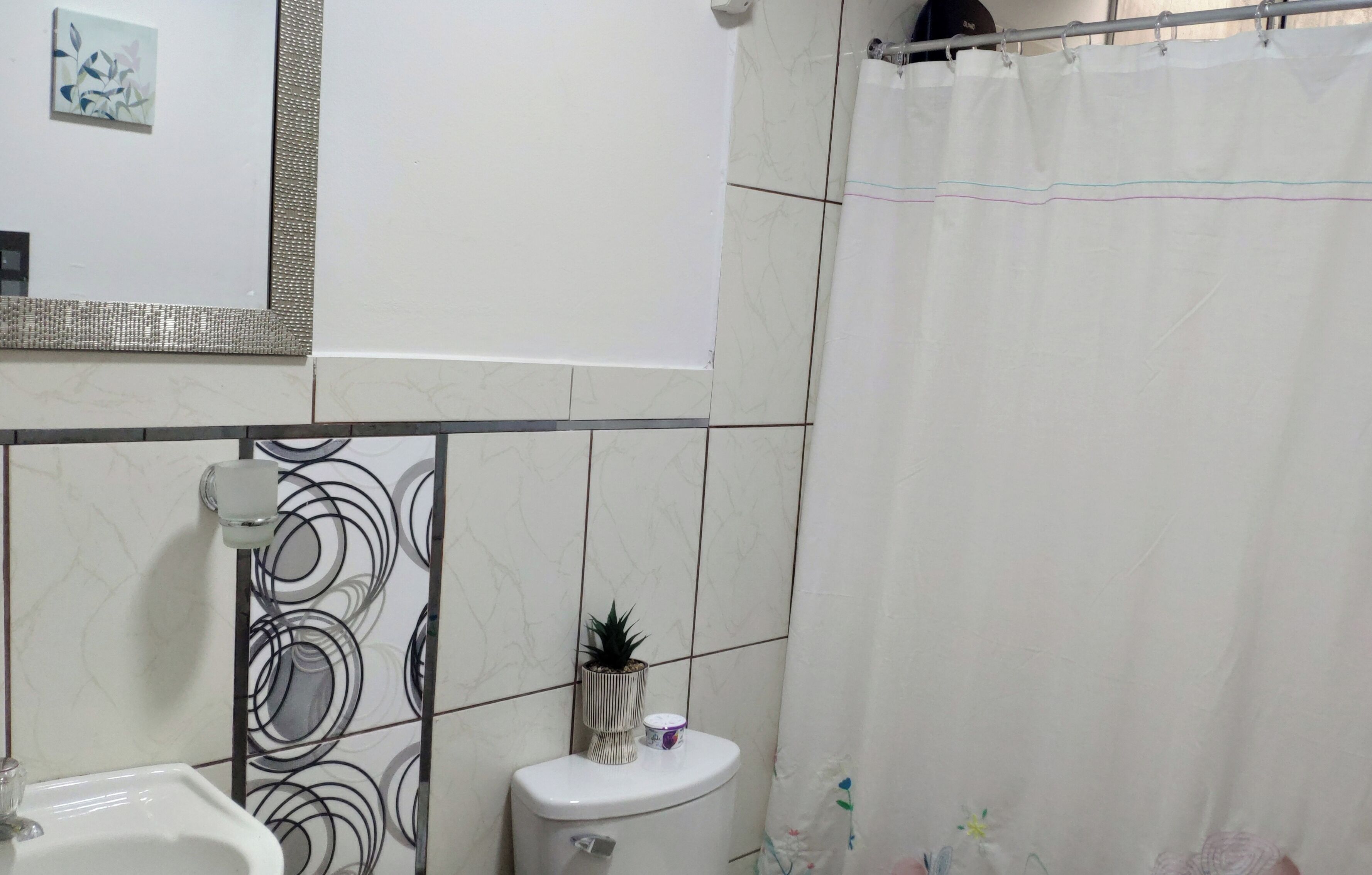 A bathroom with a toilet, sink, and a shower curtain.