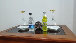 A table with two glasses, a bottle of water, a bottle of soda, and a bottle of juice. - Zona céntrica Lima Histórica (Lima)