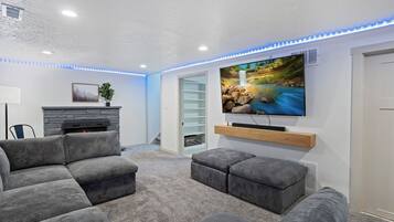 Smart-tv, eldstad, ett bordtennisbord och en stereo