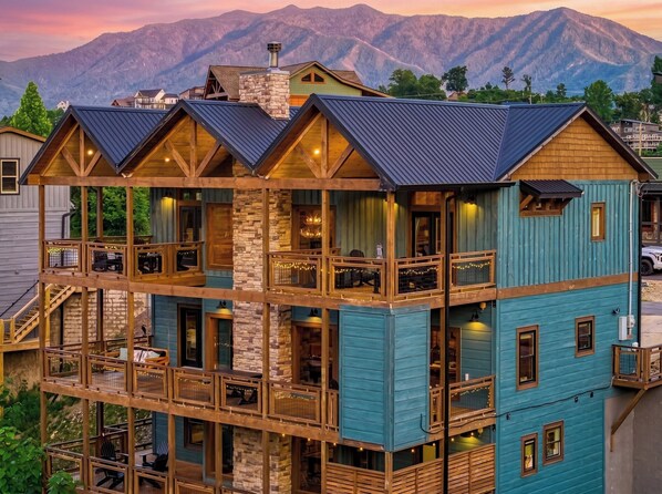 A multi-story building with a stone base, wooden balconies, and a blue exterior.