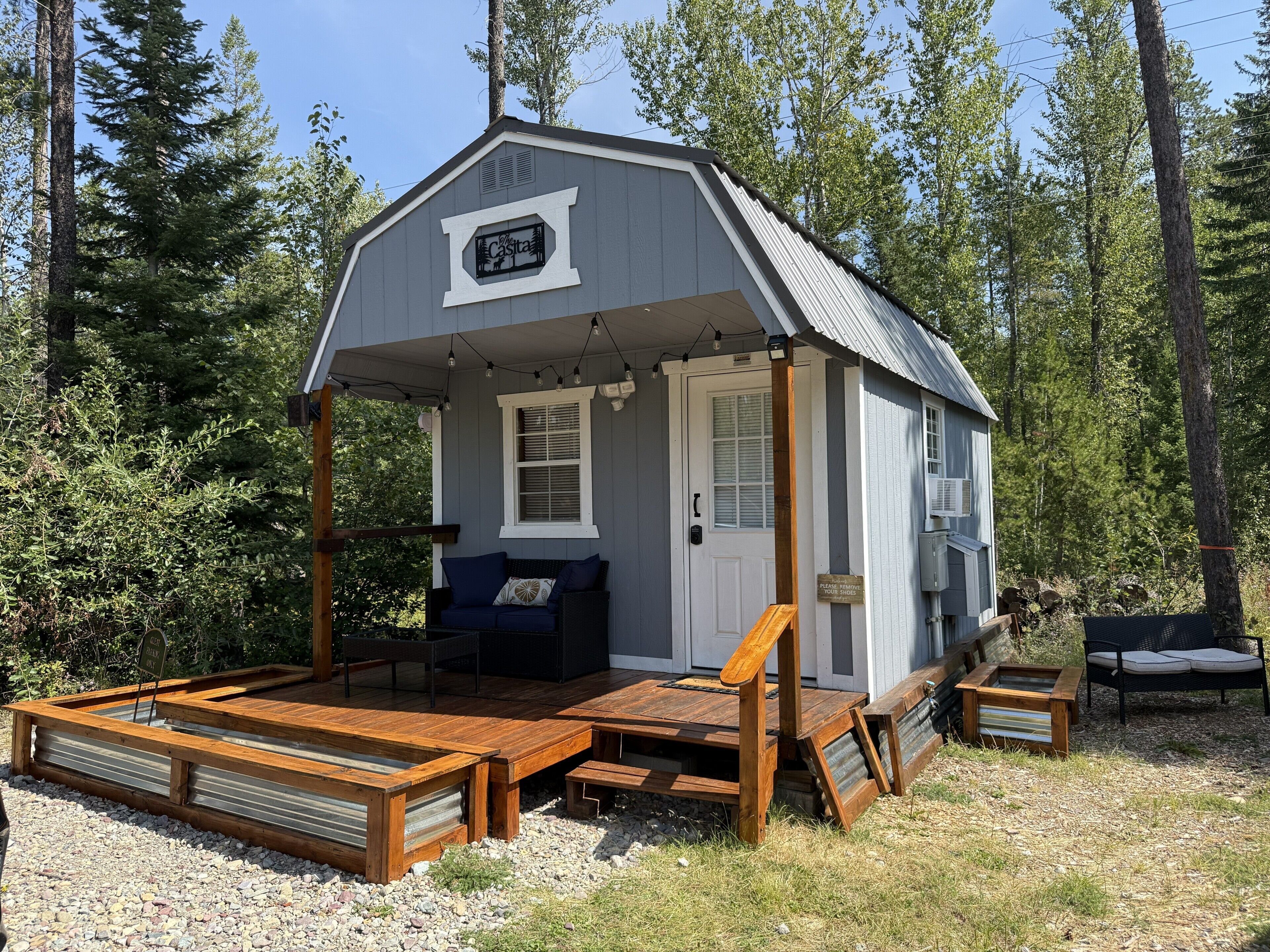 A small cabin with a porch, a bench, and a sign that reads 'Casa.'