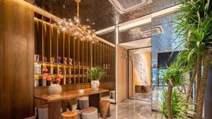 A modern lobby with a wooden reception desk, a chandelier, and a potted plant. - Jinjiang Inn (Xinyi Zhongwu Road) (Xinyi)