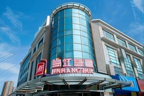 Un bĂątiment moderne dotĂ© dâune façade en verre incurvĂ©e et dâune enseigne indiquant « HAFI AM THUR ».