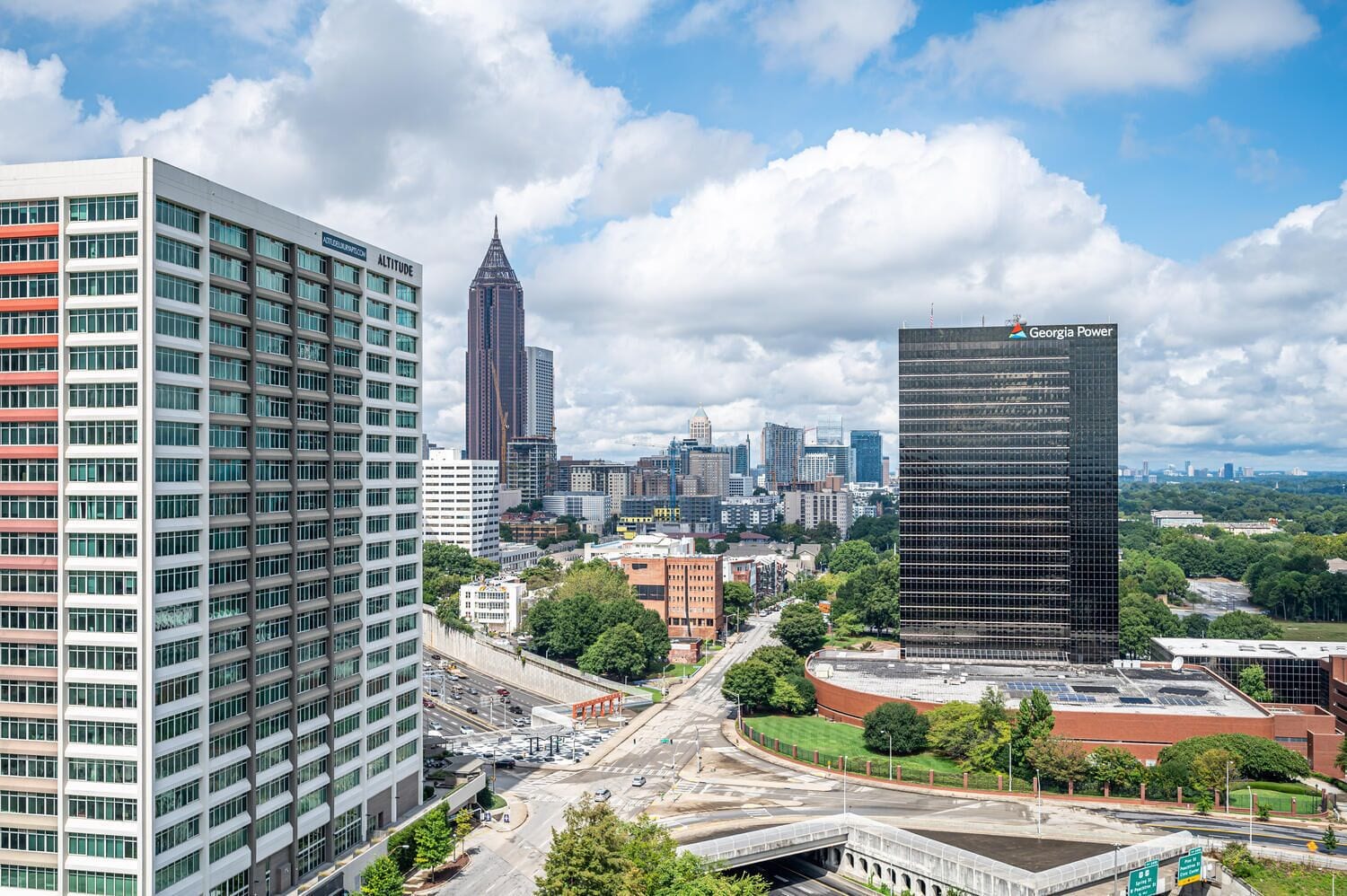 Paisagem urbana com edifícios modernos, incluindo um arranha-céu em destaque com a inscrição 'Georgia Power'.