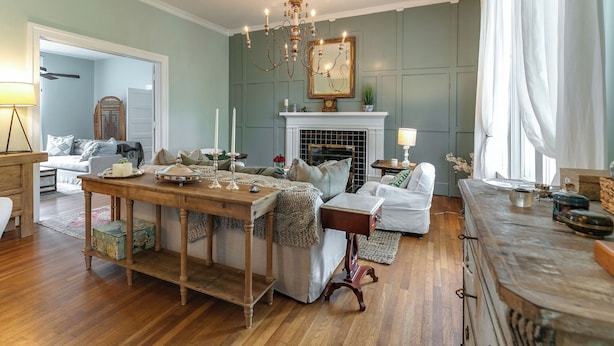 A cozy living room with a fireplace, wooden furniture, and a chandelier. - 1883 Colonial Revival Historical Renovation  (Mount Pleasant)