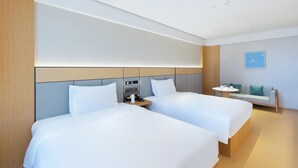 A modern hotel room with two beds, a small table, and a sofa. - Ji Hotel Hangzhou Jiaogong Road (Hangzhou)