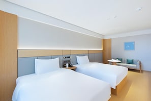 A modern hotel room with two beds, a small table, and a sofa. - Ji Hotel Hangzhou Jiaogong Road (Hangzhou)