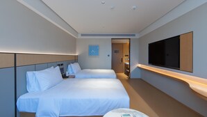 A hotel room with two beds, a TV mounted on the wall, and a small table with toiletries. - Ji Hotel Hangzhou Jiaogong Road (Hangzhou)