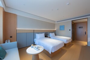 A modern hotel room with two beds, a small table with a cup and saucer, and a sofa. - Ji Hotel Hangzhou Jiaogong Road (Hangzhou)
