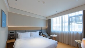 A hotel room with a large bed, bedside tables, a desk, and a chair. - Ji Hotel Hangzhou Jiaogong Road (Hangzhou)
