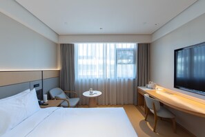 A hotel room with a bed, a desk, a chair, a small table, and a TV. - Ji Hotel Hangzhou Jiaogong Road (Hangzhou)