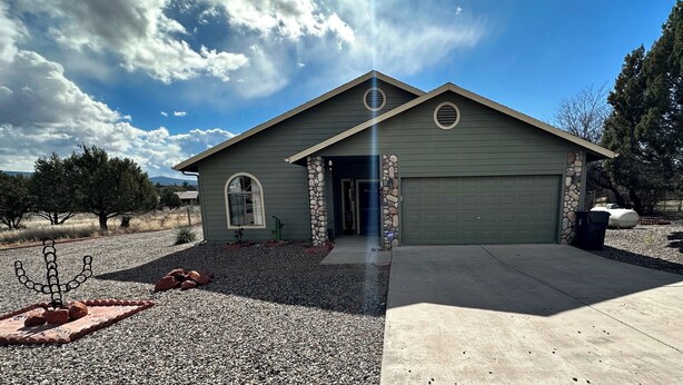 A single-story house with a garage, a stone pillar, and a decorative metal sculpture in the front yard. - Javelina House - Lake Montezuma (Lake Montezuma)