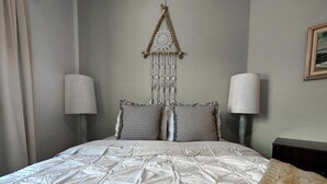 A neatly made bed with a white duvet, two pillows, and a wall hanging above. - Javelina House - Lake Montezuma (Lake Montezuma)