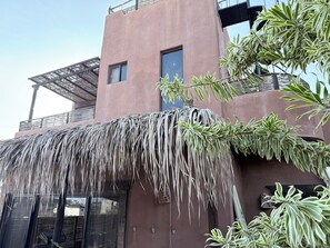 A building with a thatched roof and potted plants.