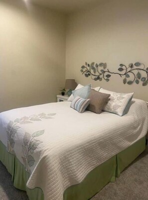 Restful retreat with a large bed, nightstand, and potted plant.